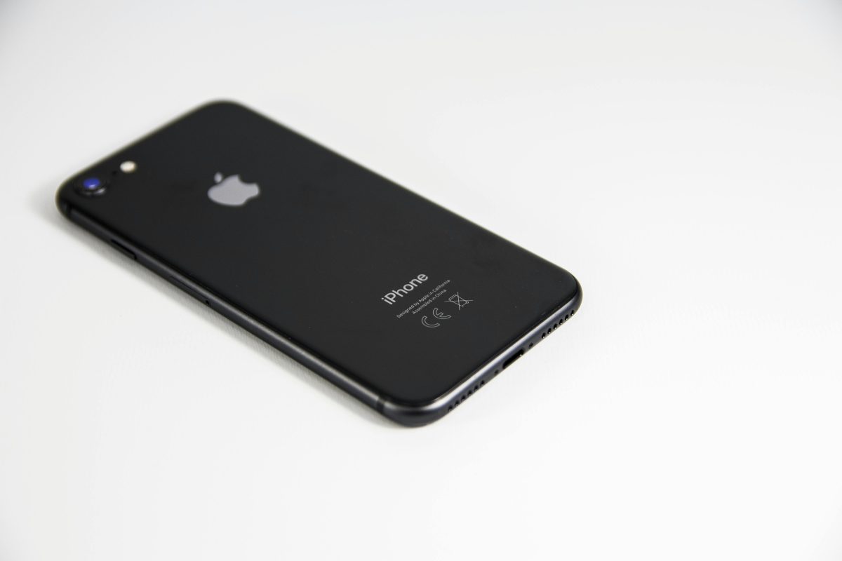 Čierny iPhone na bielom pozadí, zadná strana telefónu s logom a kamerou.