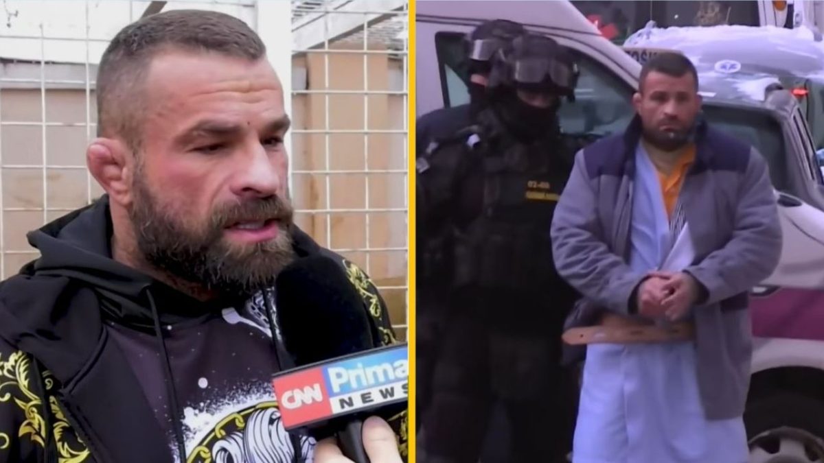Osoba hovorí do mikrofónu CNN Prima News; vedľa stojí muž v putách sprevádzaný políciou.