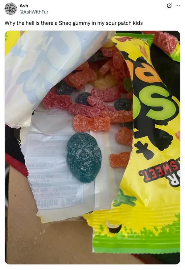 Otvoreté cukríky Sour Patch Kids s modrým želé v tvare hlavy medzi farebnými cukríkmi.