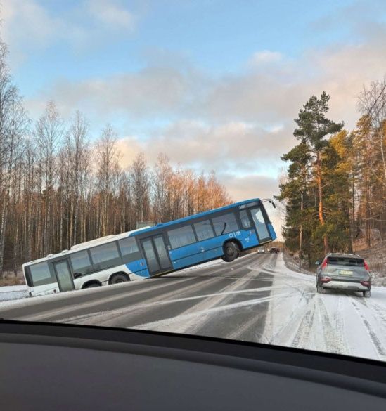 Autobus sa šmýka na zľadovatenej ceste pokrytej snehom v zimnej krajine blízko lesa.