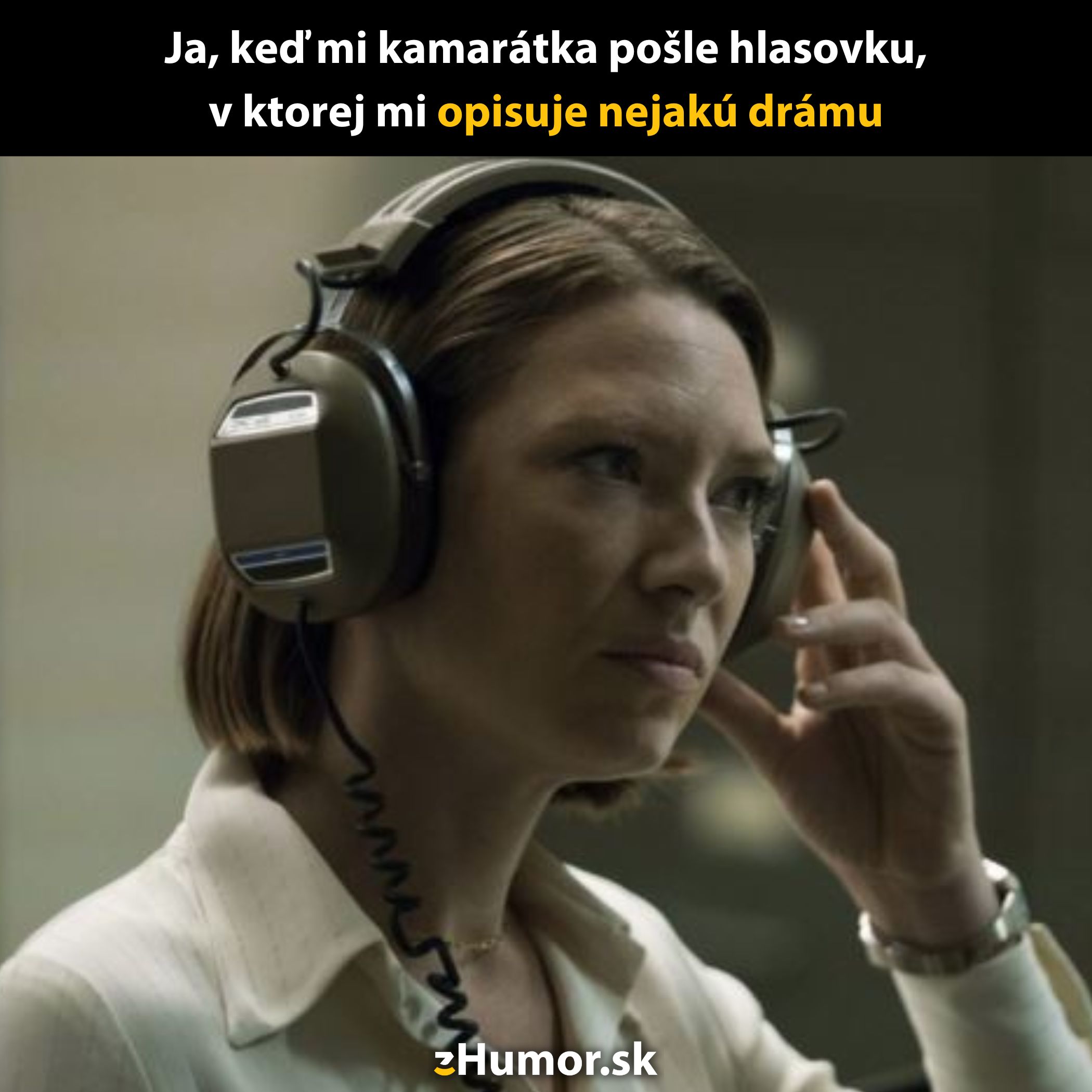 Žena počúva hlasovú správu so zvedavým výrazom, s veľkými slúchadlami na ušiach.