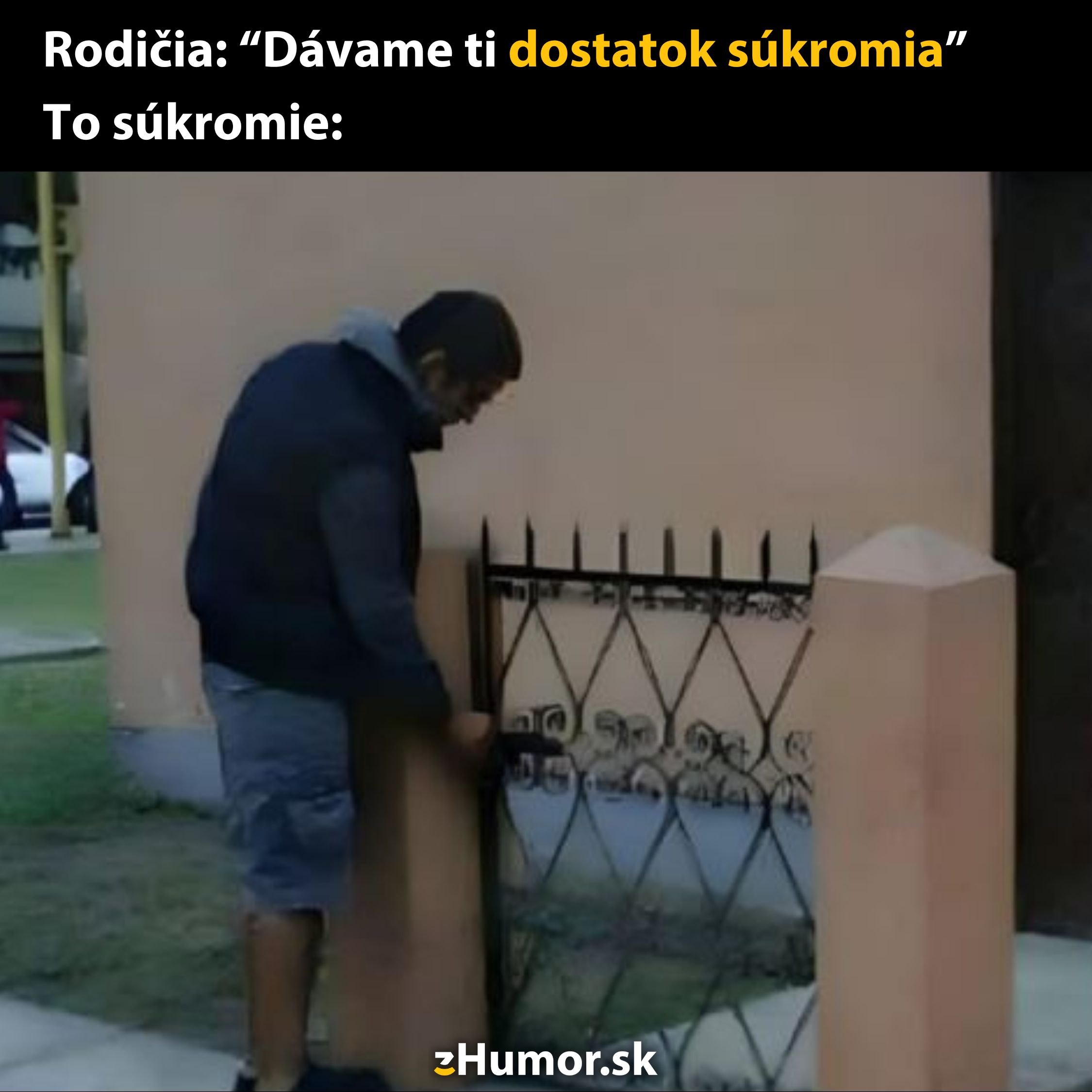 Muž sa pozerá cez otvorenú malú bránu, symbolizujúcu iróniu súkromia poskytovaného rodičmi.