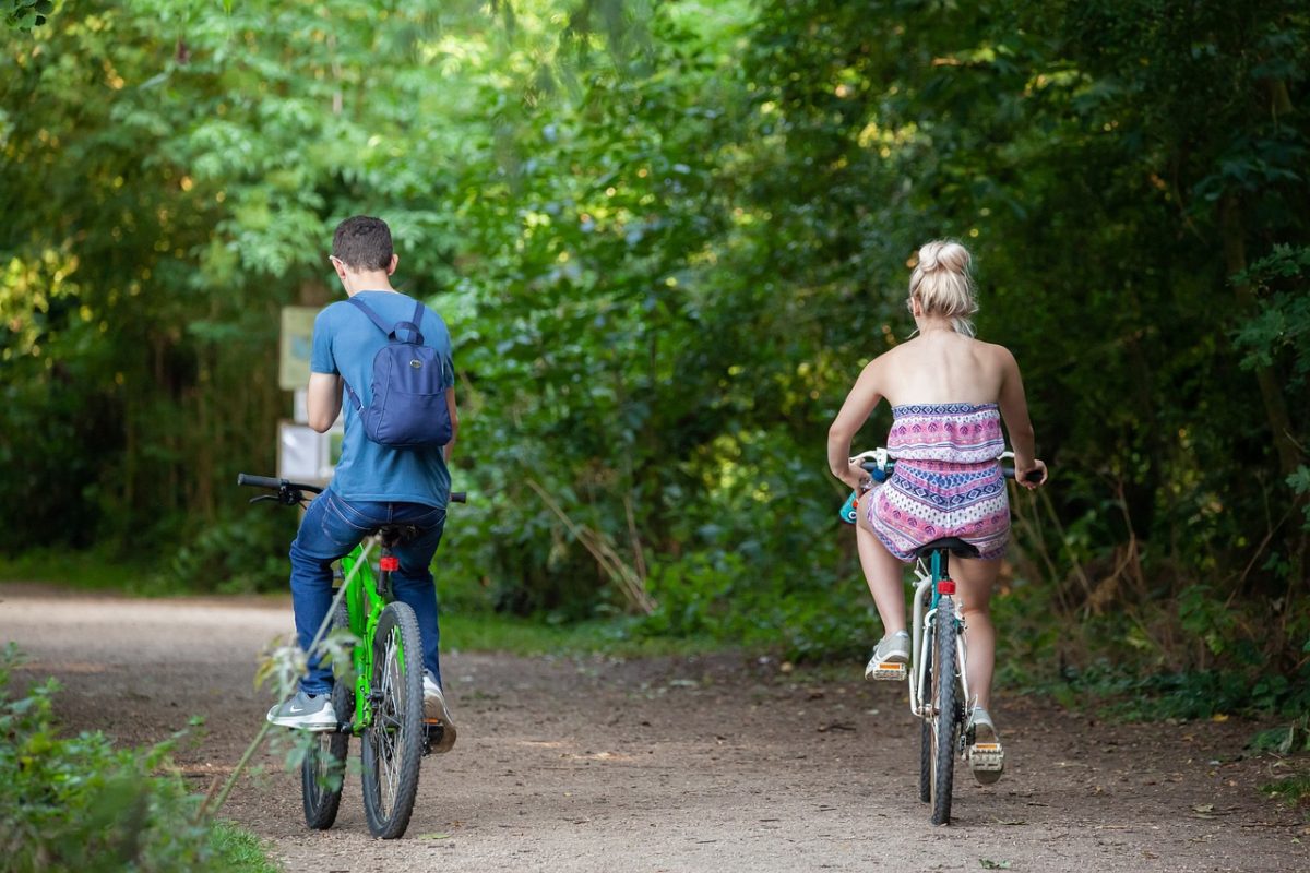bicycle, riding on a path, bike in park, couple on bike, riding a bike, green bike, green path