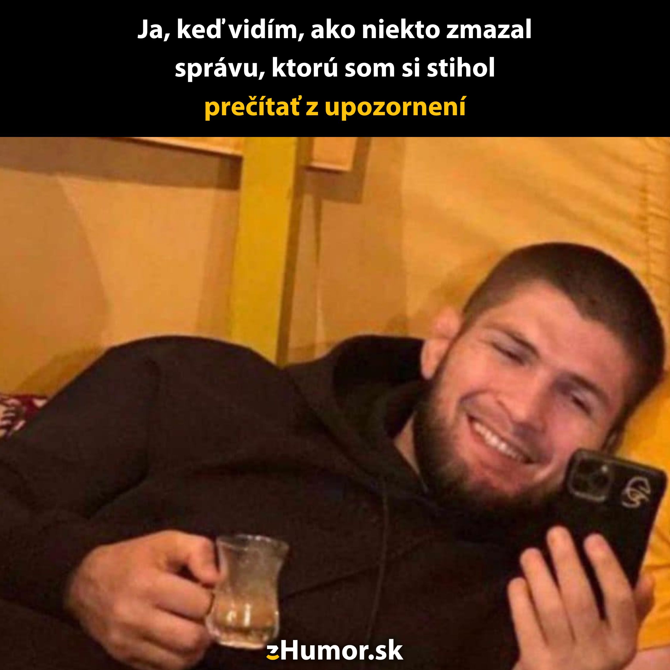 Muž sa usmieva pri pohľade na telefón, držiac šálku čaju, s textom o prečítaní zmazanej správy z upozornenia.