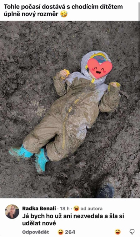 Dieťa v overale leží v blate, zábavný moment vonkajšej hry v daždivom počasí.