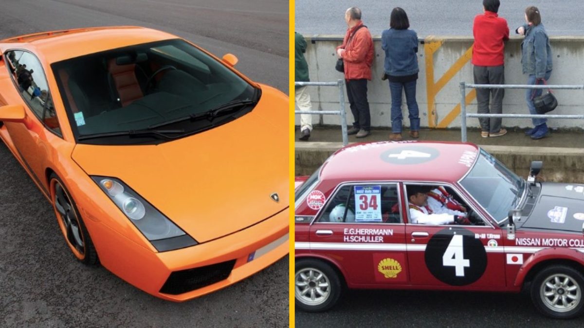 Oranžové športové auto na ceste a vedľa neho červené závodné auto pri bariére s ľuďmi.