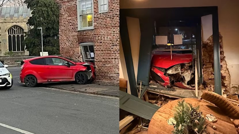 Červené auto havarovalo do tehlového domu, čím spôsobilo výrazné poškodenie a veľkú dieru v stene.