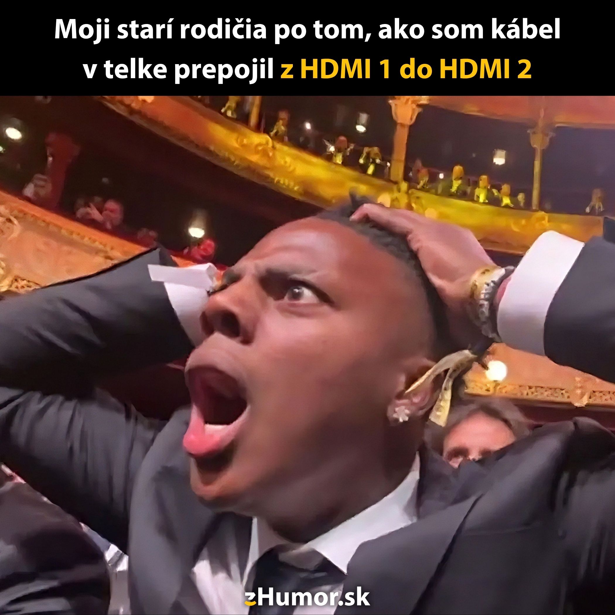 Osoba v obleku s prekvapivým výrazom pri pohľade na divadelné publikum, zábavná reakcia.