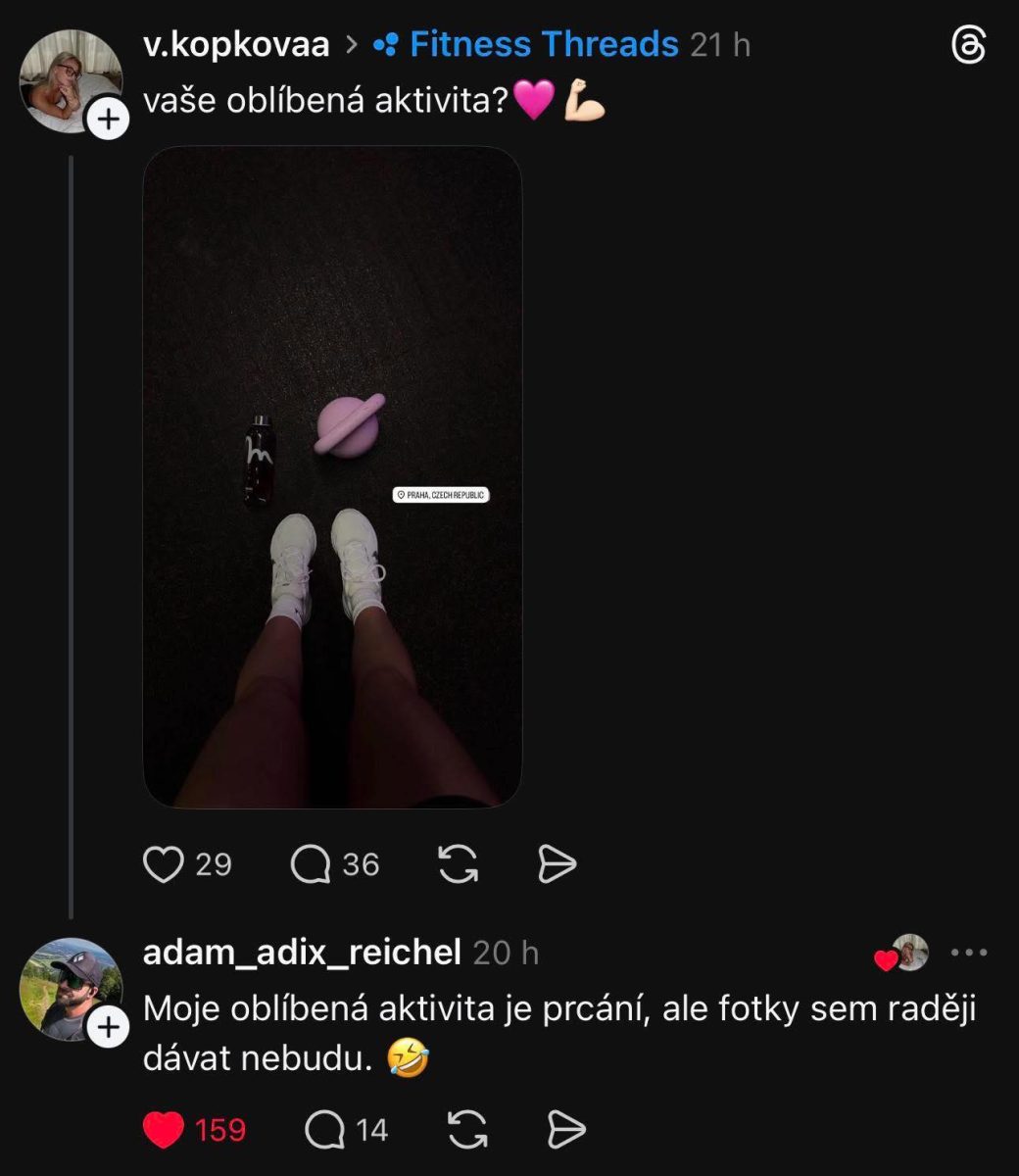Užívateľ ukazuje svoje nohy v teniskách na podlahe vedľa fľaše vody a ružového kettlebellu.