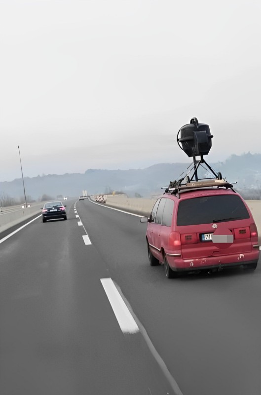 Červené auto so zariadením na streche jazdiace po diaľnici v hmlistom počasí.