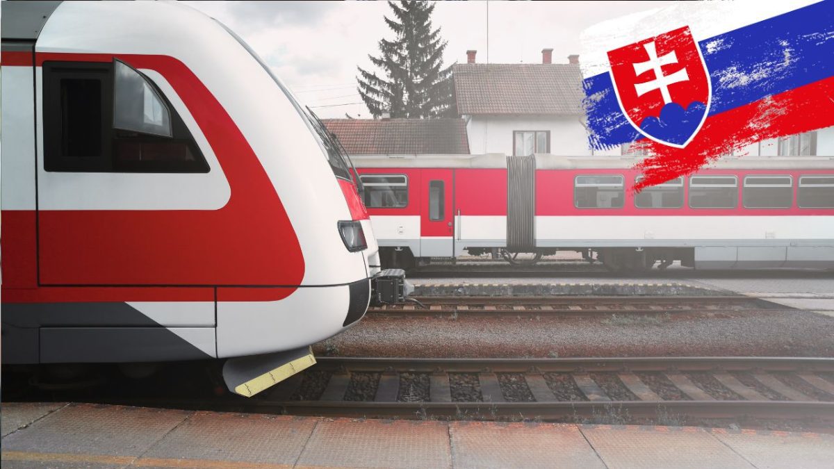 Slovenský vlak na stanici, v pozadí budova s lesom, vo farbách Slovenska.