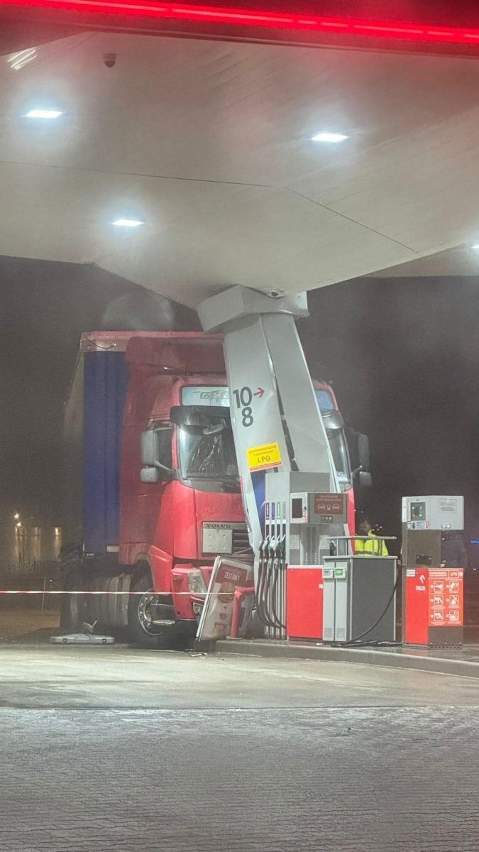 Kamión narazil do strechy na čerpacej stanici, poškodený stojan. Noc, jasné osvetlenie, nehodový incident.
