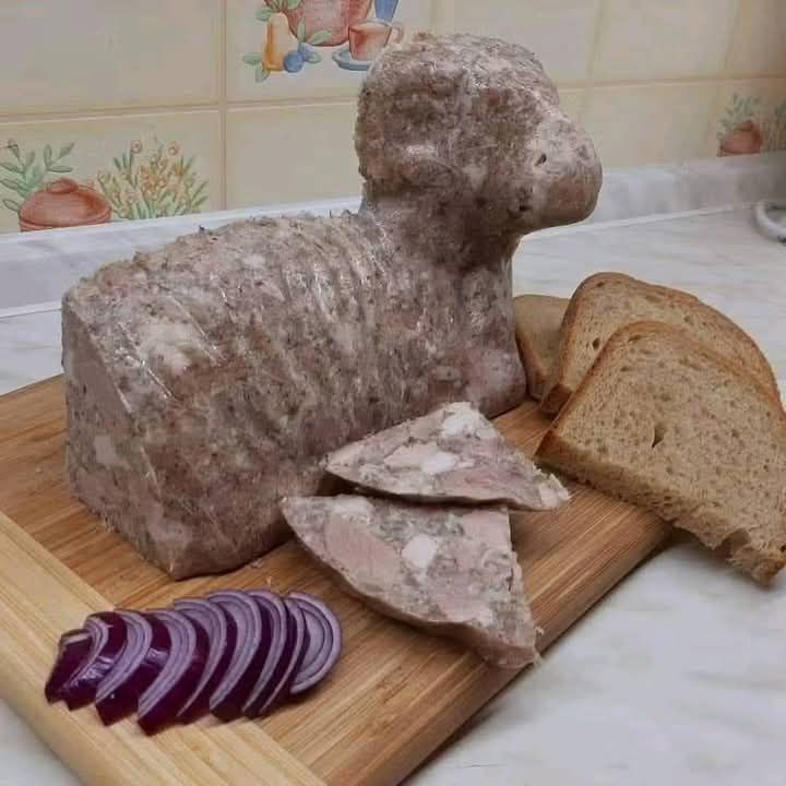 Chutná paštéta baranček s chlebom a cibuľou na drevenej doske v kuchyni. Skvelá pochúťka na desiatu.