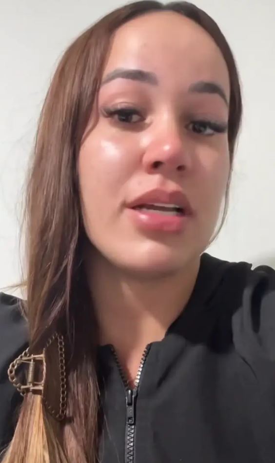 Osoba v čiernom oblečení s dlhými hnedými vlasmi, vyjadrujúcimi emocionálny výraz, zblízka.