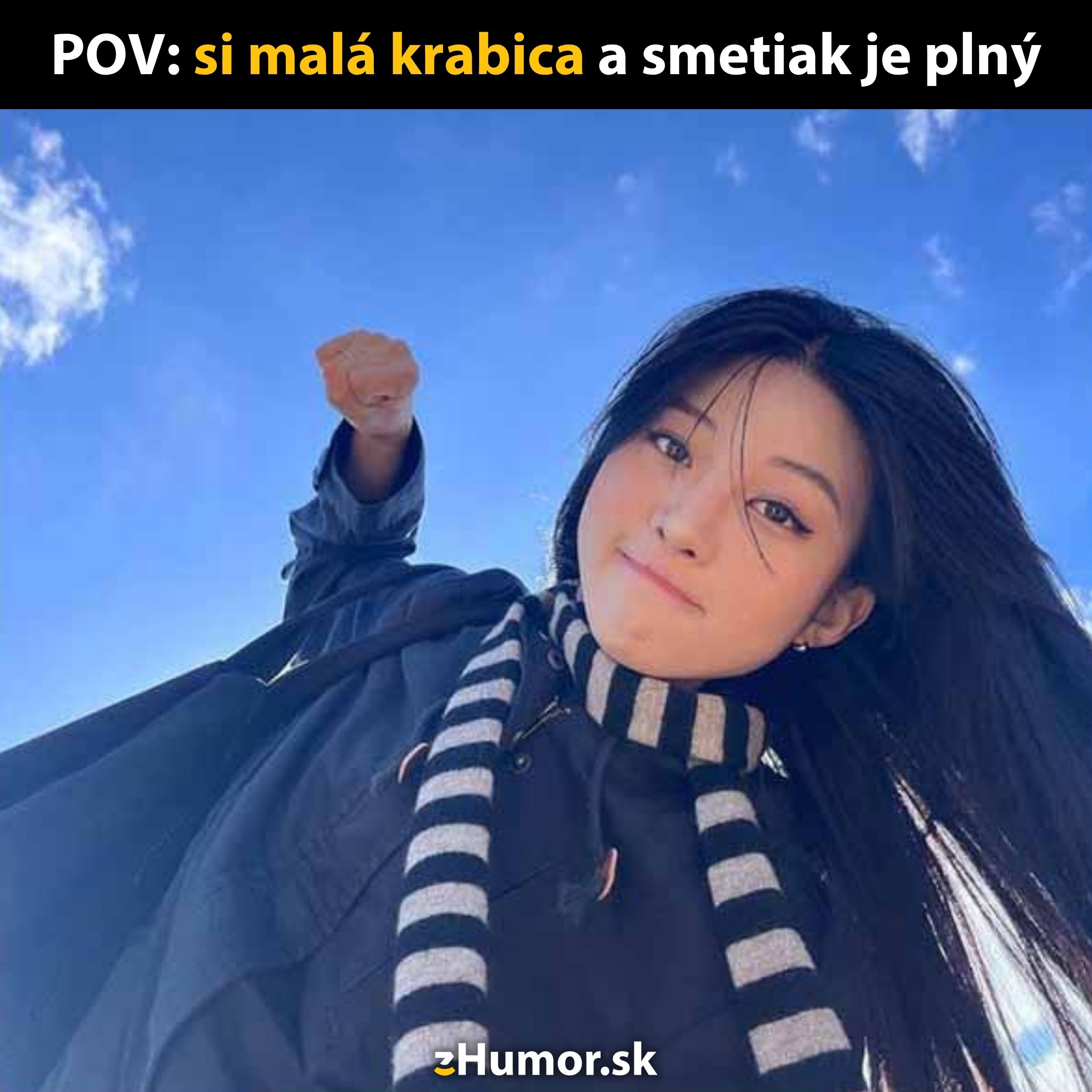 Mladá žena pozerá zospodu s modrou oblohou na pozadí, oblečená v šále.