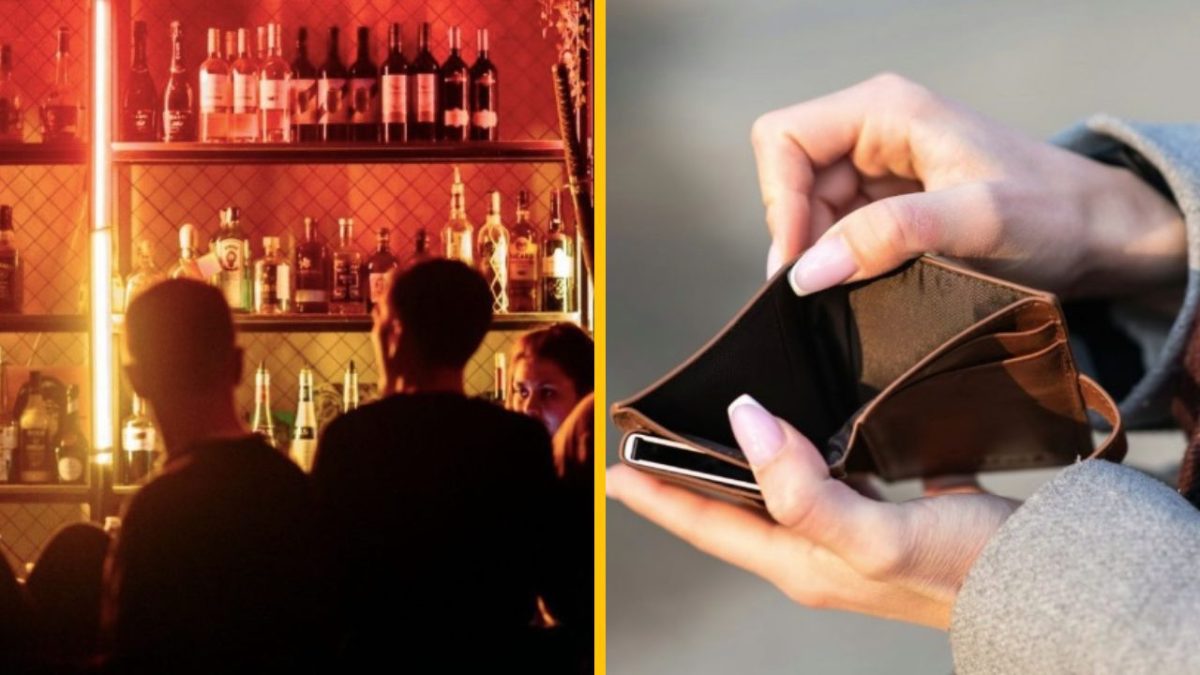 Bar s fľašami alkoholu na poličkách vedľa prázdnej peňaženky s mobilom v rukách osoby.
