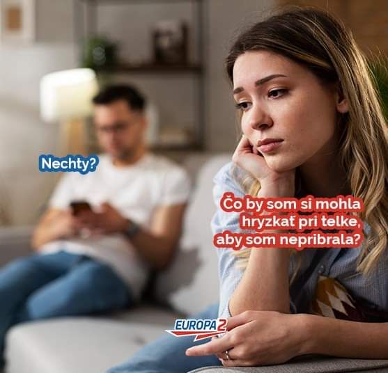 Žena premýšľa o zdravom snacku pri pozeraní TV, muž na pozadí používa mobil. Textová bublina: „Nechty?“
