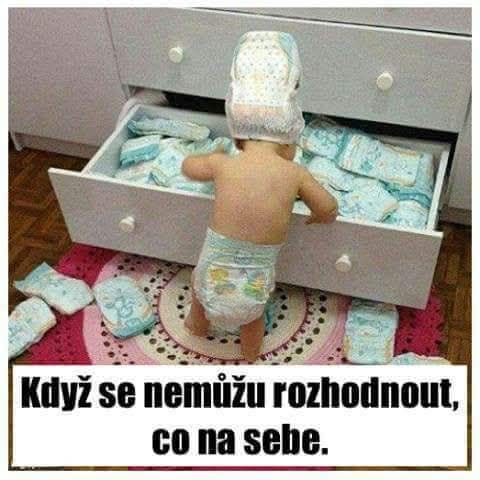 Dieťa stojace pred šuflíkom plným plienok, zamýšľajúc sa nad výberom oblečenia.