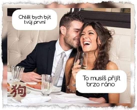 Pár sa smeje pri stole v reštaurácii, muž šeptá žene do ucha, obaja držia poháre.