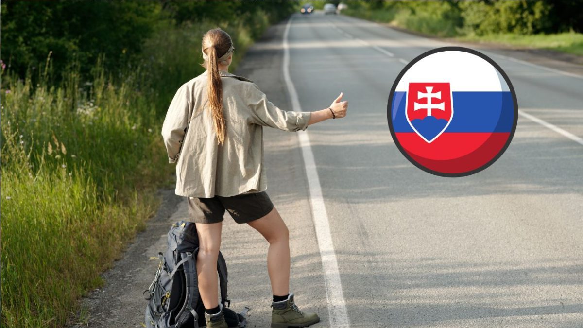 Stopárka na ceste so slovenskou vlajkou, ktorá symbolizuje cestovanie na Slovensku.