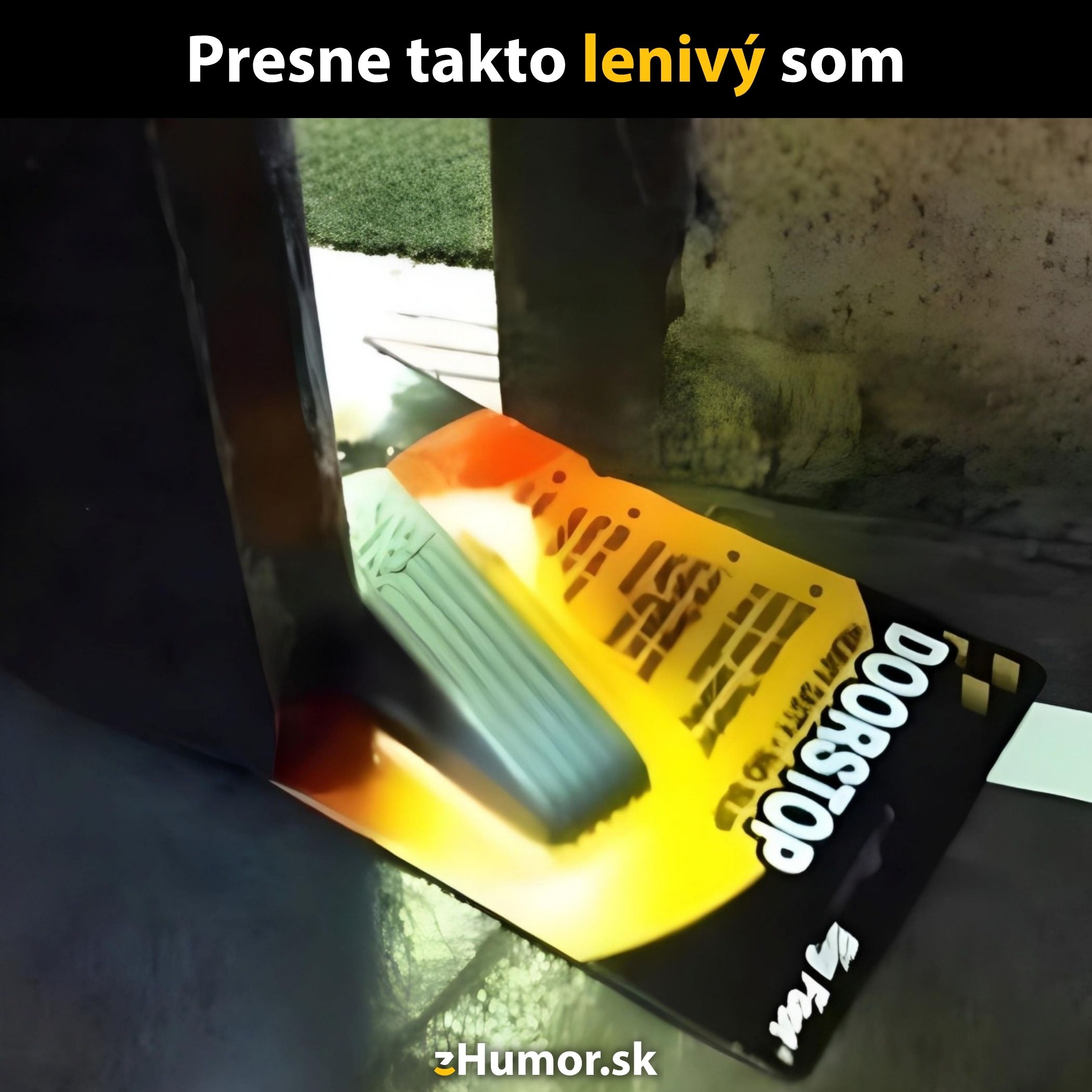 Dverový zarážok použitý bez vybalenia z obalu, symbol lenivosti a humoru.