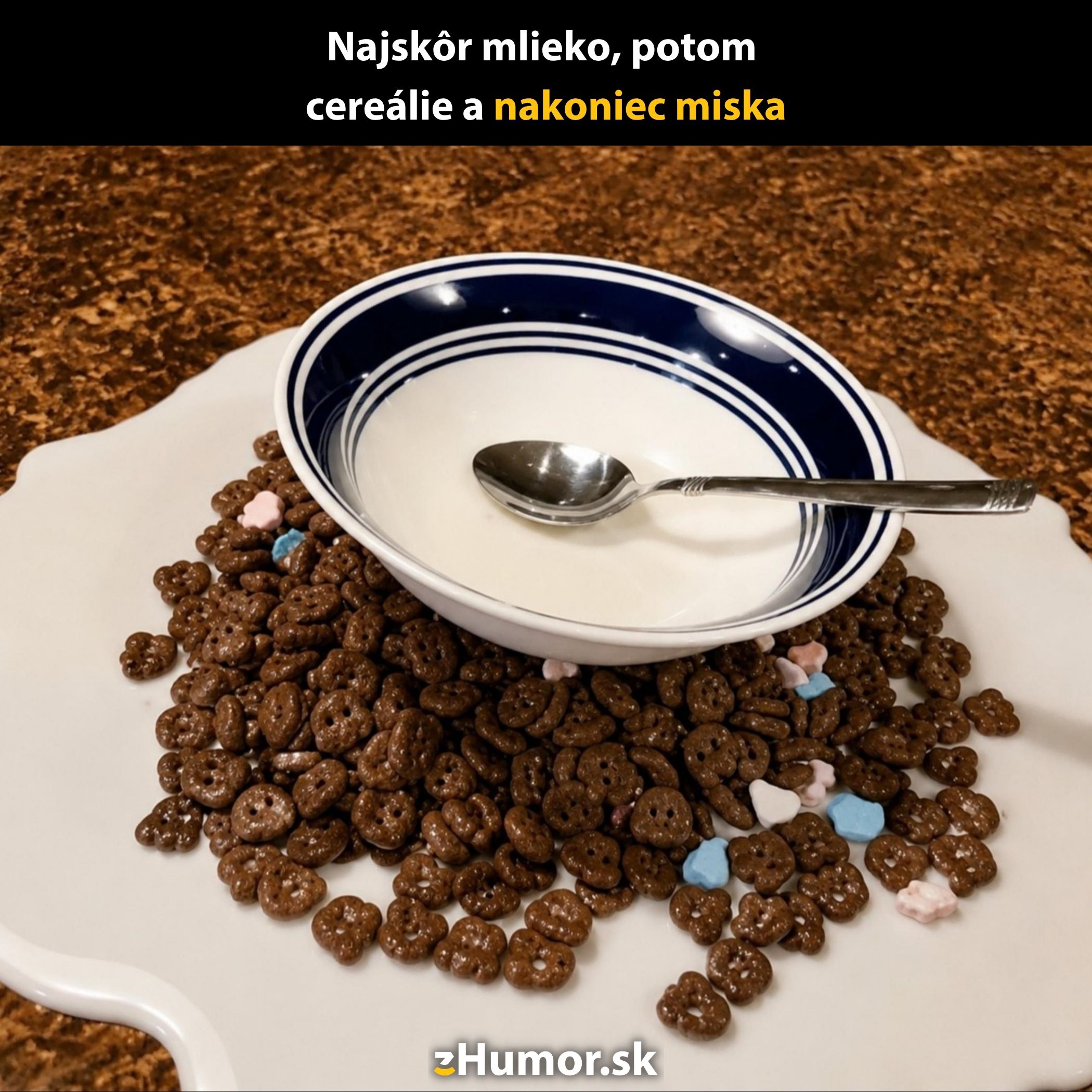 Miska s mliekom položená dolu dnom na čokoládových cereáliách, vedľa polievková lyžica.