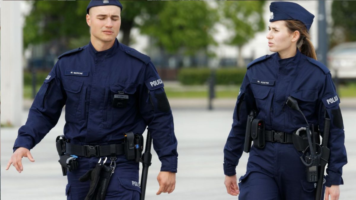 Policajní dôstojníci v uniforme pri hliadke na ulici počas denného svetla.