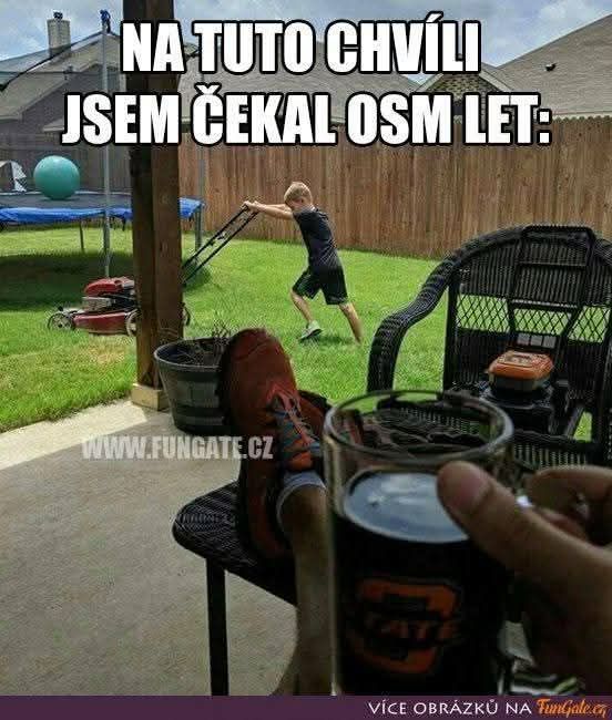 Chlapec kosí trávnik, zatiaľ čo dospelý relaxuje s nápojom na verande - humorný moment očakávania.