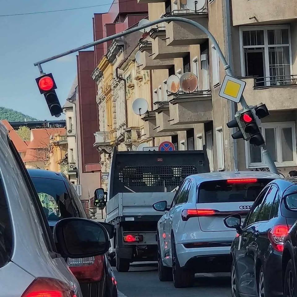 Dopravná zápcha v meste, pokrivený semafor na križovatke, nadväzujúci rad áut.