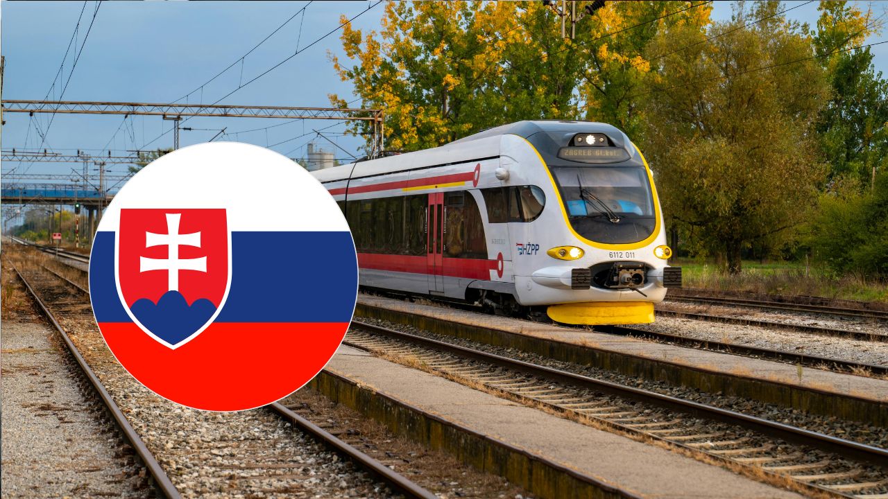 Moderný vlak na stanici s motívom slovenskej vlajky v popredí.