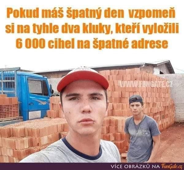 Dvaja stavební robotníci pred hromadou tehál, ktorú vyložili na nesprávnom mieste.