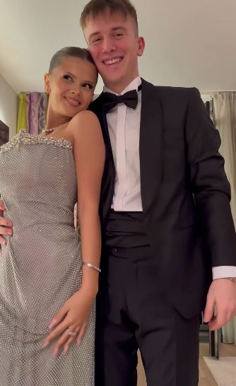 Pár v elegantnom oblečení pózujúci pre fotografiu v interiéri.