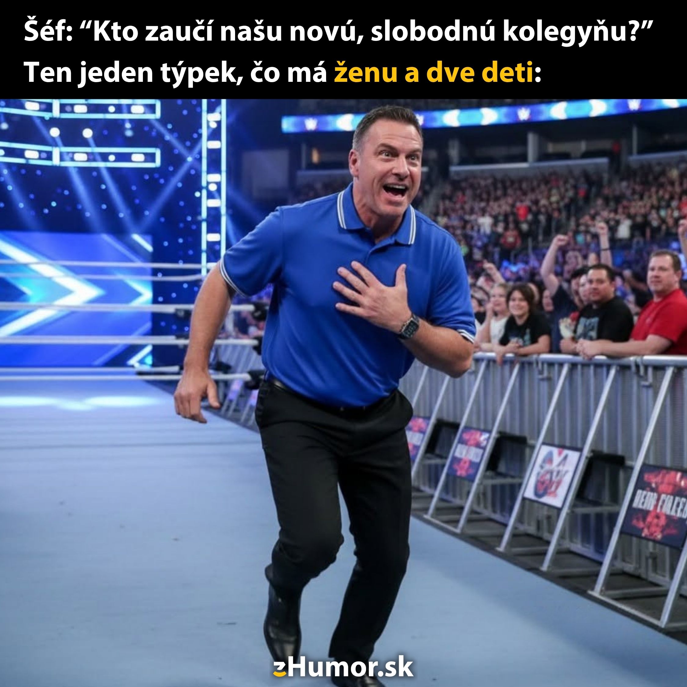 Muž v modrom tričku beží na wrestlingovom ringe so sálou plnou divákov.