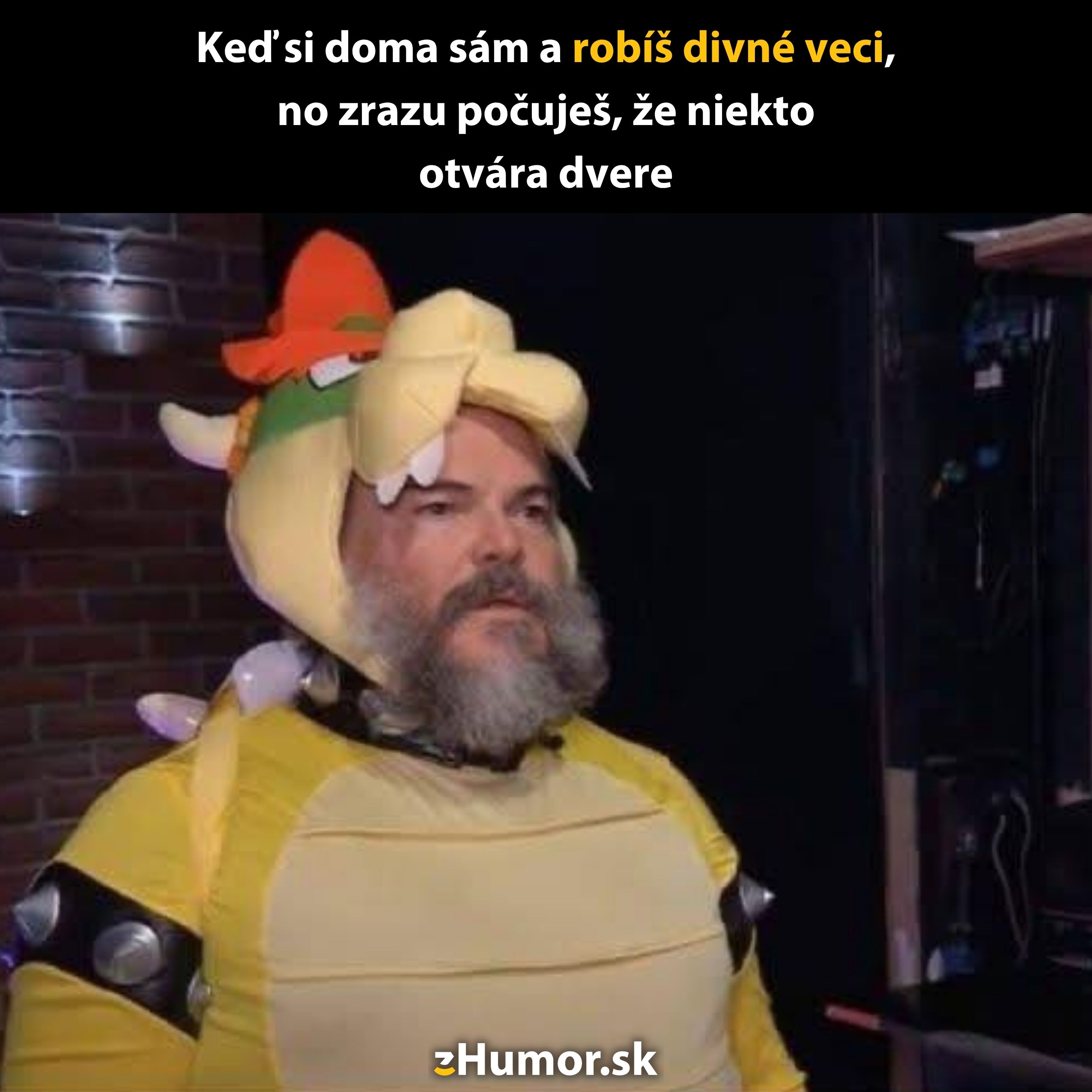 Muž v žltom kostýme s rohatou čiapkou stojí pred čiernym pozadím s vtipným textom v hornej časti.