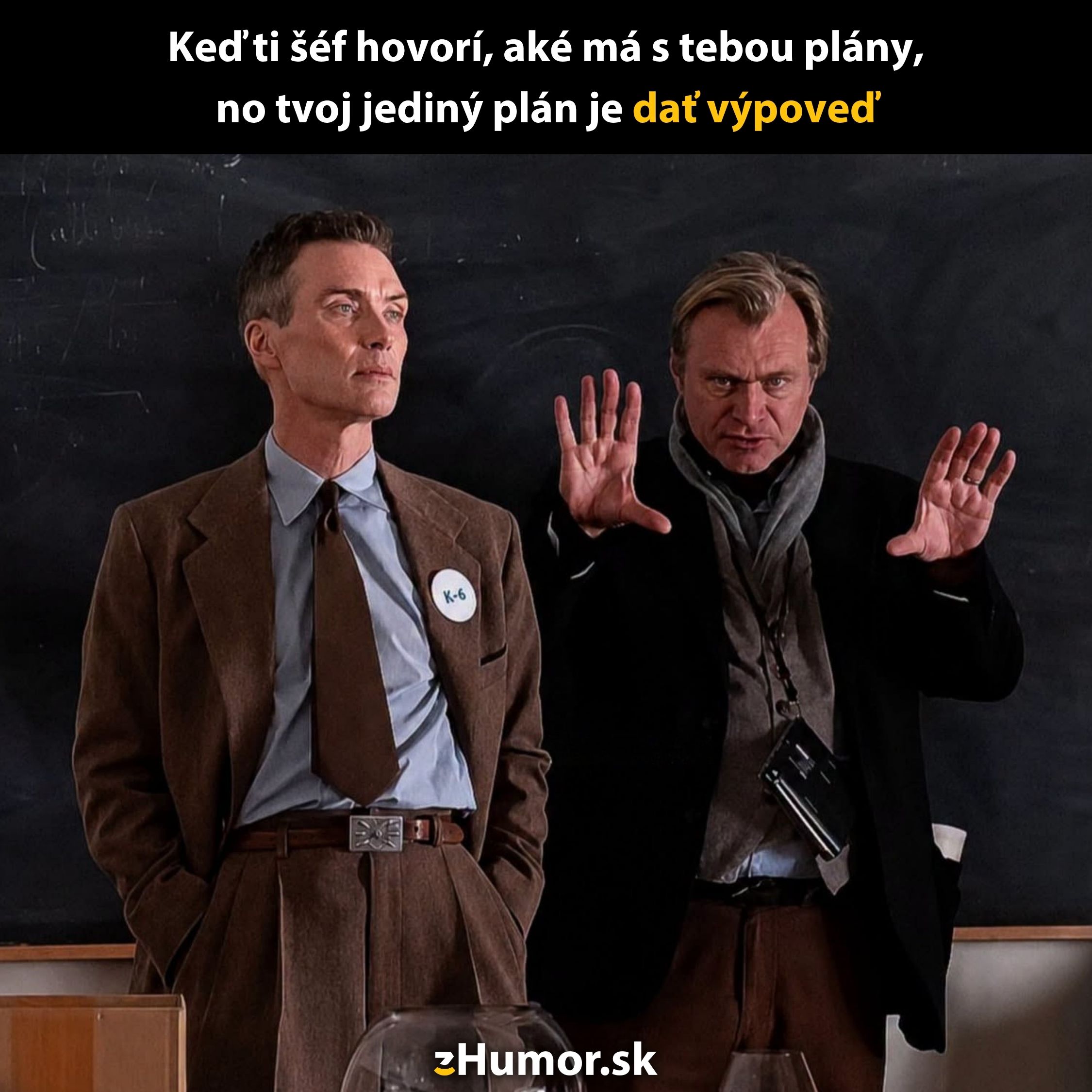 Dvaja muži v oblekoch pred tabuľou, s humorným textom o práci a výpovedi.
