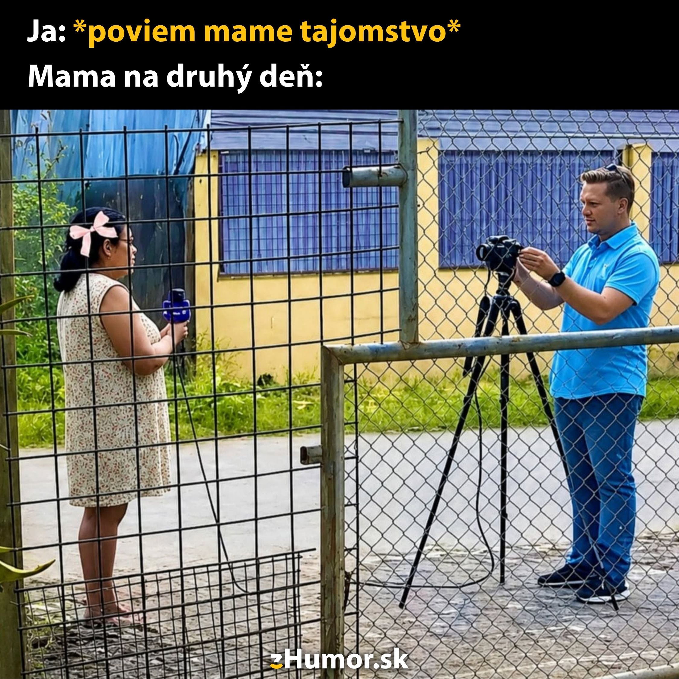 Muž v modrej košeli nahráva ženu cez mreže, obaja sa nachádzajú v vonkajšom prostredí.