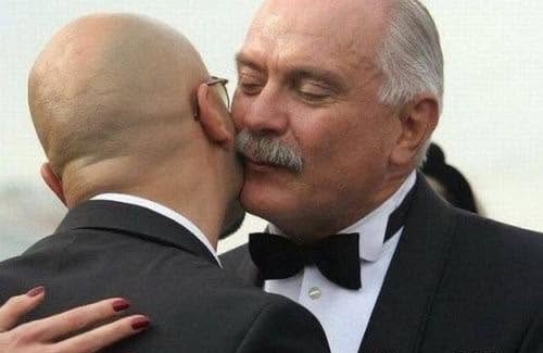 Ospievali sa dvaja muži formálnom oblečení v priateľskom objatí na spoločenskej udalosti.