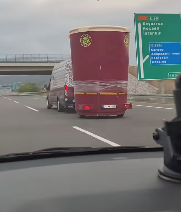 Vtipný pohľad na diaľnici: auto ťahá veľký model pohára na kávu. Cesta smeruje do Istanbulu.