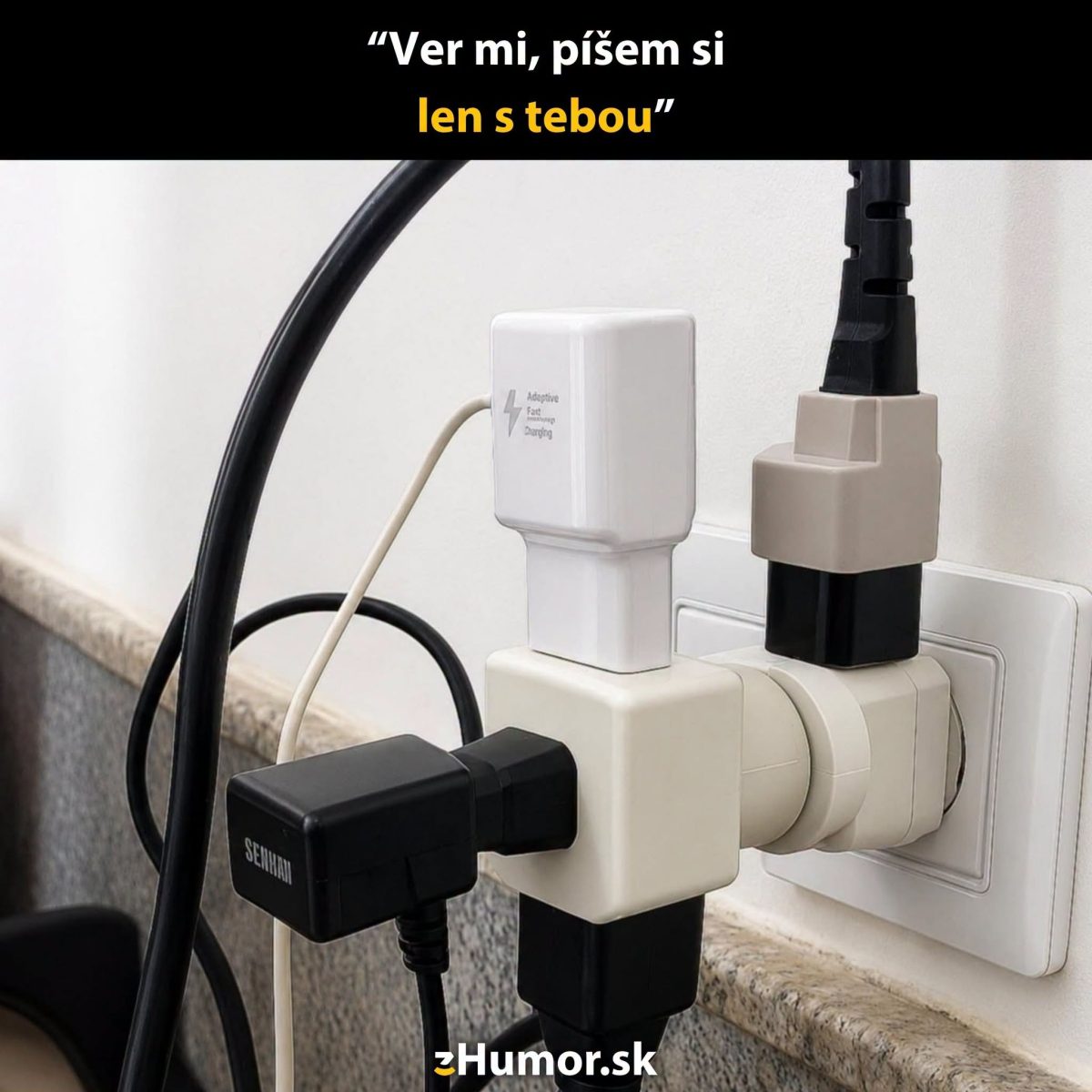 Viaczásuvkový adaptér s pripojenými nabíjačkami na stene, žartovný nápis: Ver mi, píšem si len s tebou.
