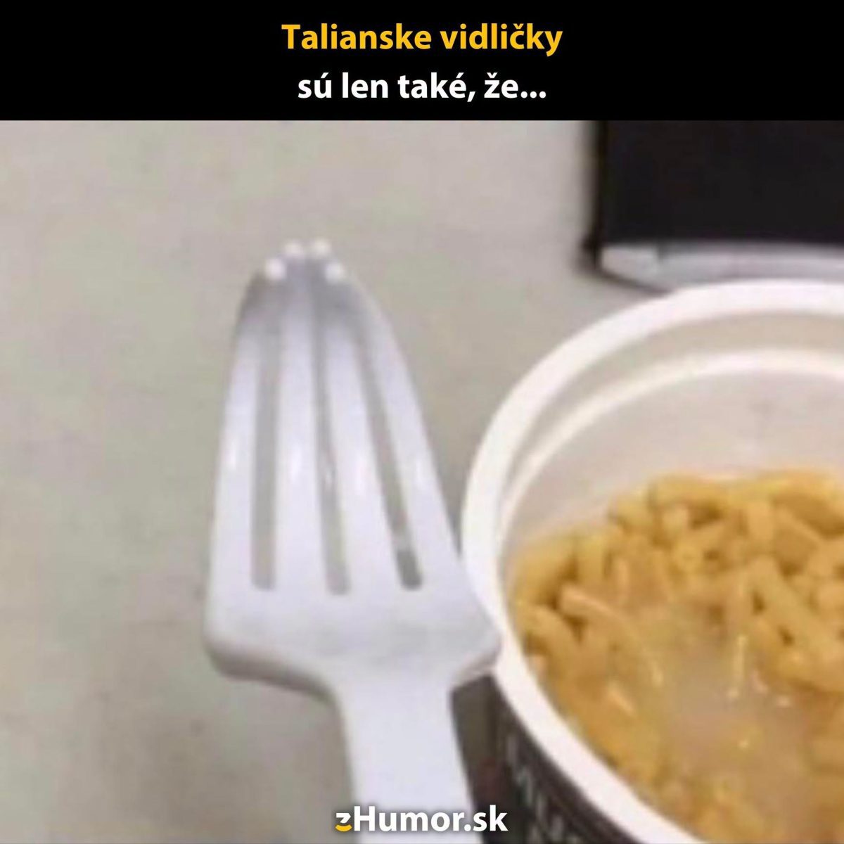 Plastová vidlička pripravená na cestoviny vo farebnom pohári, zachytená v humornom kontexte.