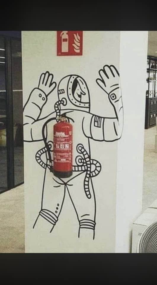 Nástenná kresba astronauta s hasiaci prístroj ako batoh, kreatívna dekorácia na stene.