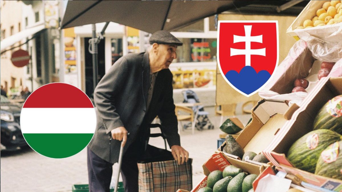 Starší muž nakupuje na trhu s ovocím; slovenská a maďarská vlajka v pozadí.