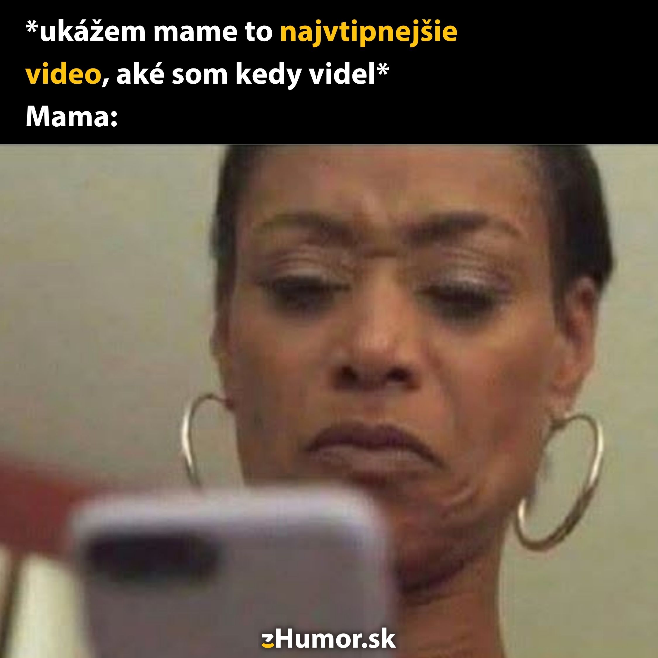 Mama skepticky pozerá na telefón so zamračeným výrazom.