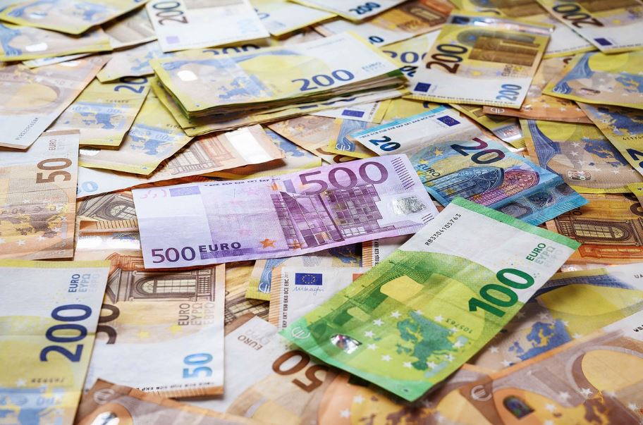 Eurobankovky v rôznych hodnotách rozložené na stole zobrazujú európsku menu a finance.