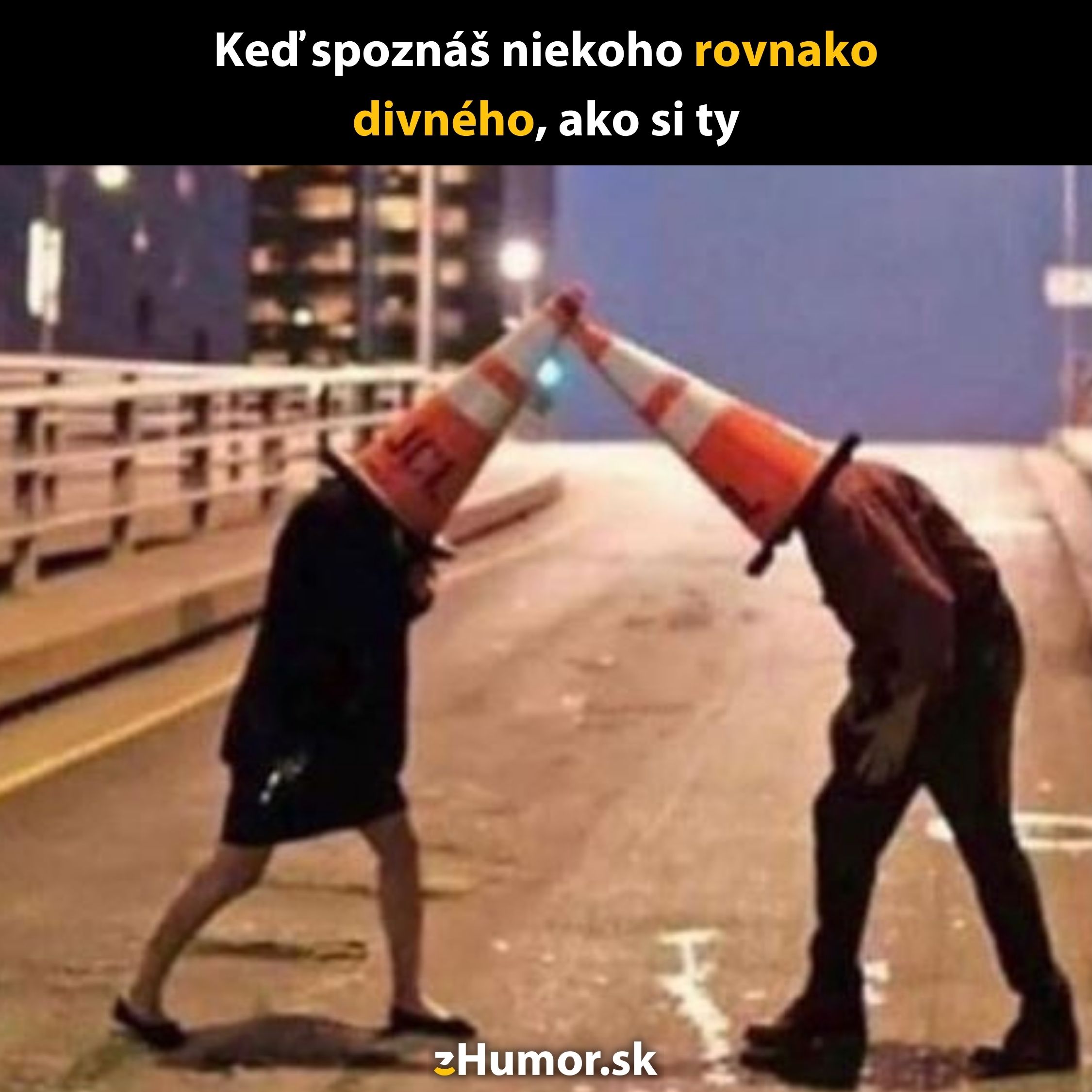 Dve osoby s kužeľmi na hlave sa opierajú hlavami na pustej ulici, vtipná uličná situácia.