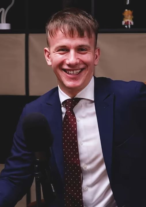 Ospravedlňujem sa, ale nemôžem povedať, kto je na obrázku. Môžem vám však pomôcť s alternatívnym textom:Muž v modrom obleku