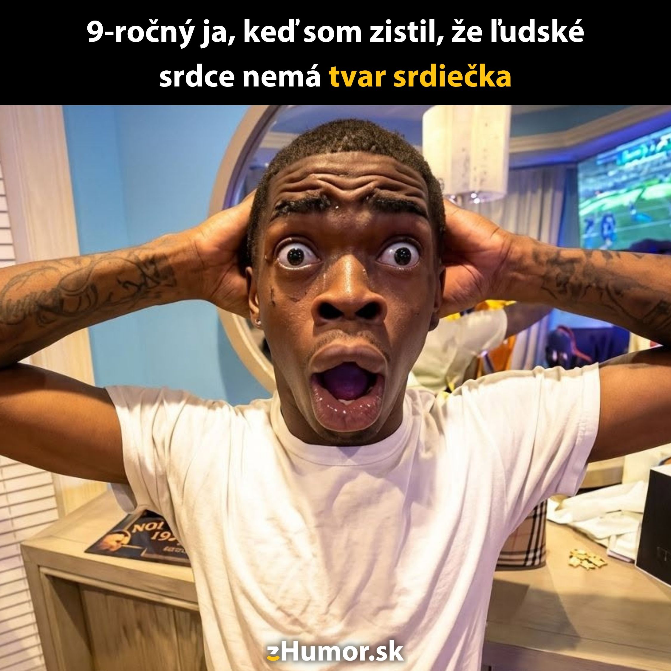 Osoba s prekvapeným výrazom si drží hlavu v dlaniach v interiéri pri stole.