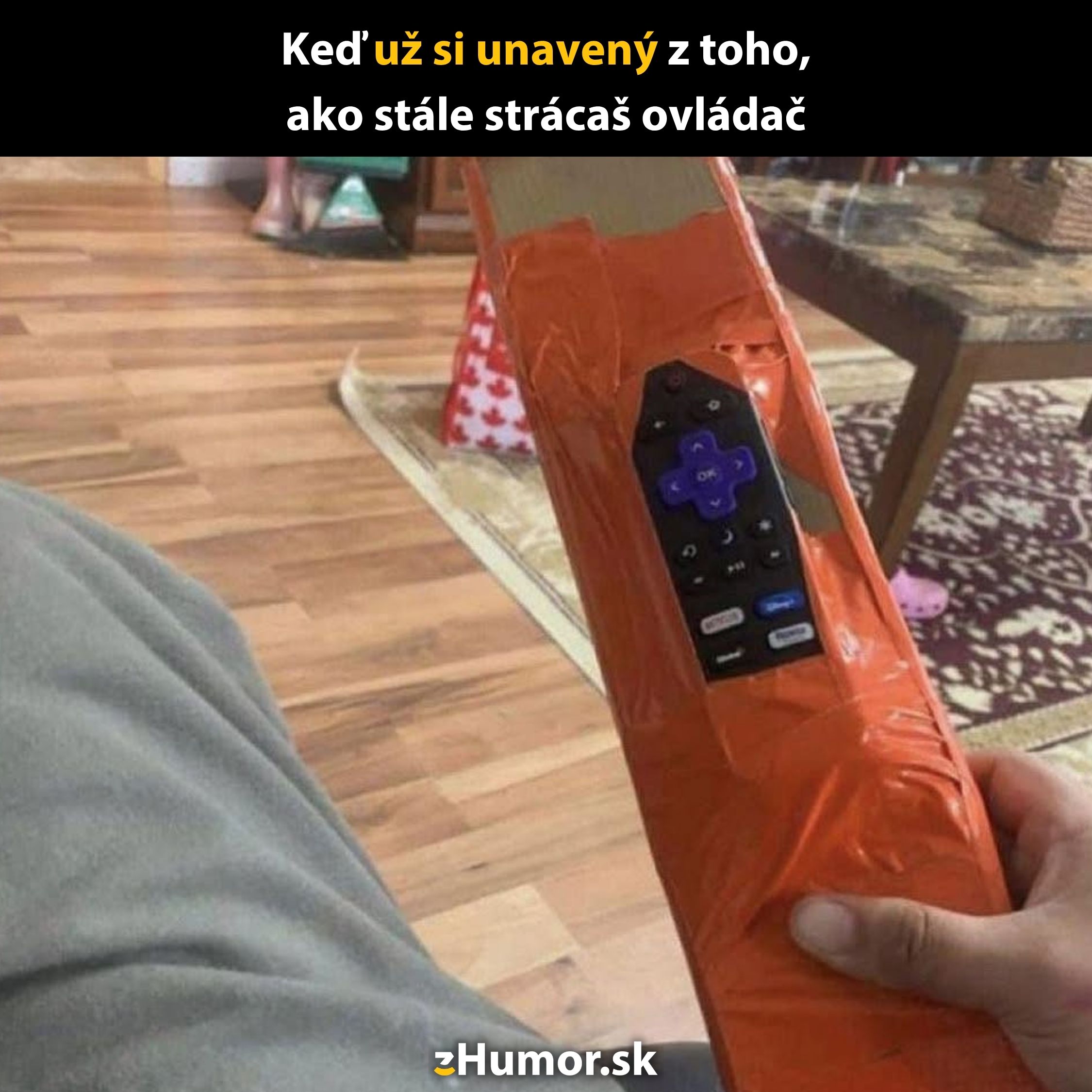 Dlhý ovládač obalený páskou na dreve, aby sa neztratil, pre praktické udržanie v domácnosti.