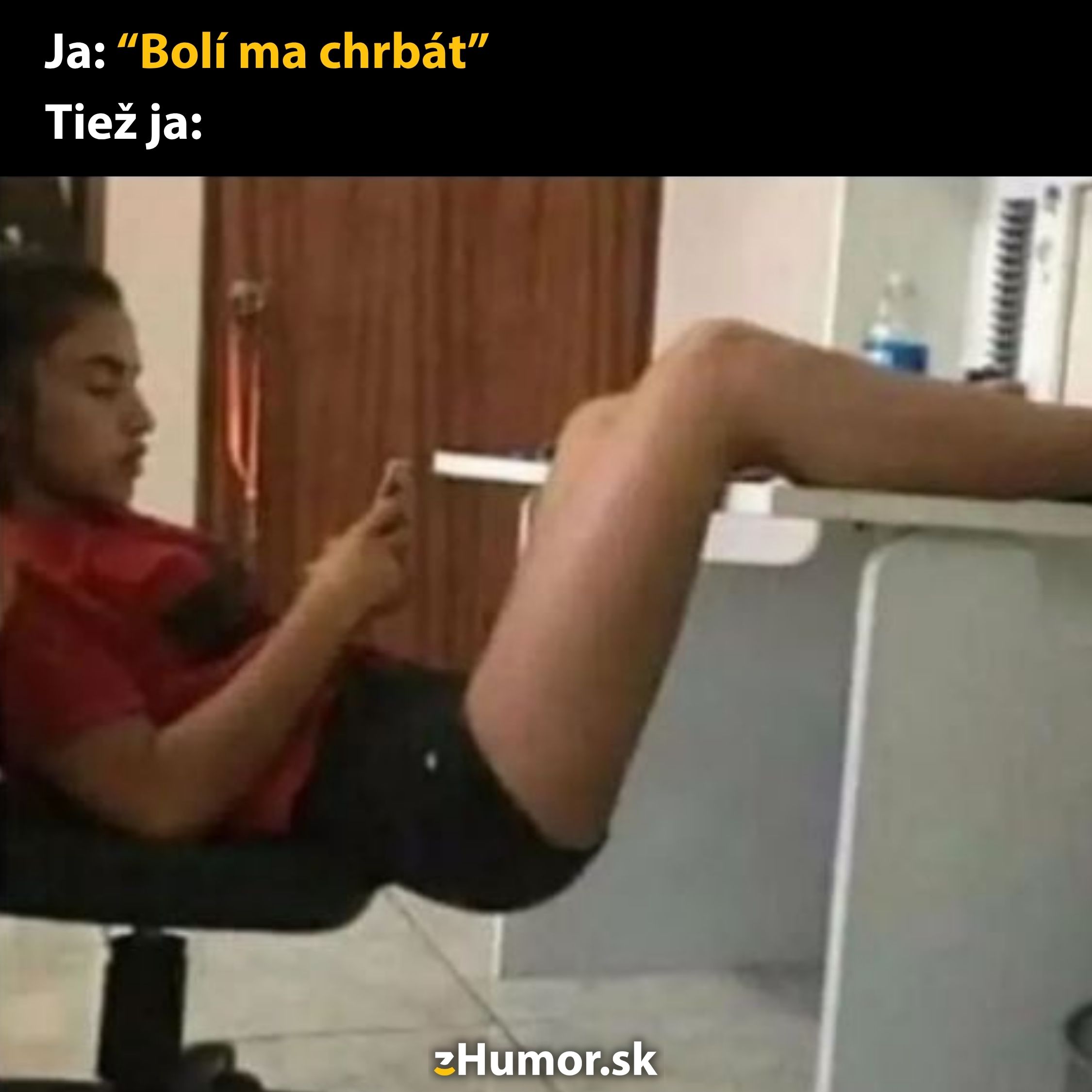 Osoba sedí na stoličke s nohami vyloženými na stôl, pozerá sa na mobil. Text: Bolí ma chrbát.