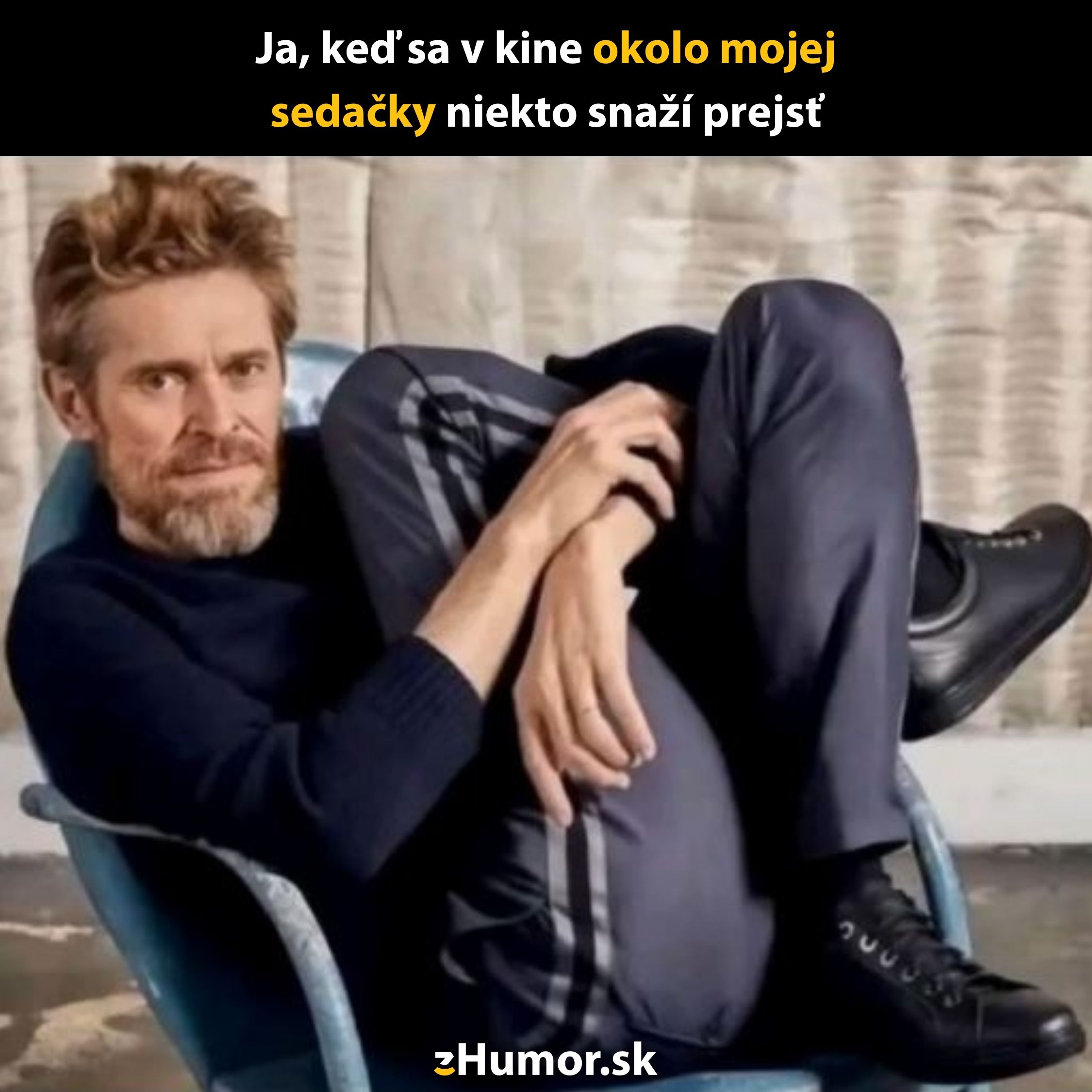 Muž sedí skrútený na stoličke vtipne ilustrujúc nepríjemný moment v kine, keď niekto prechádza okolo jeho sedačky.